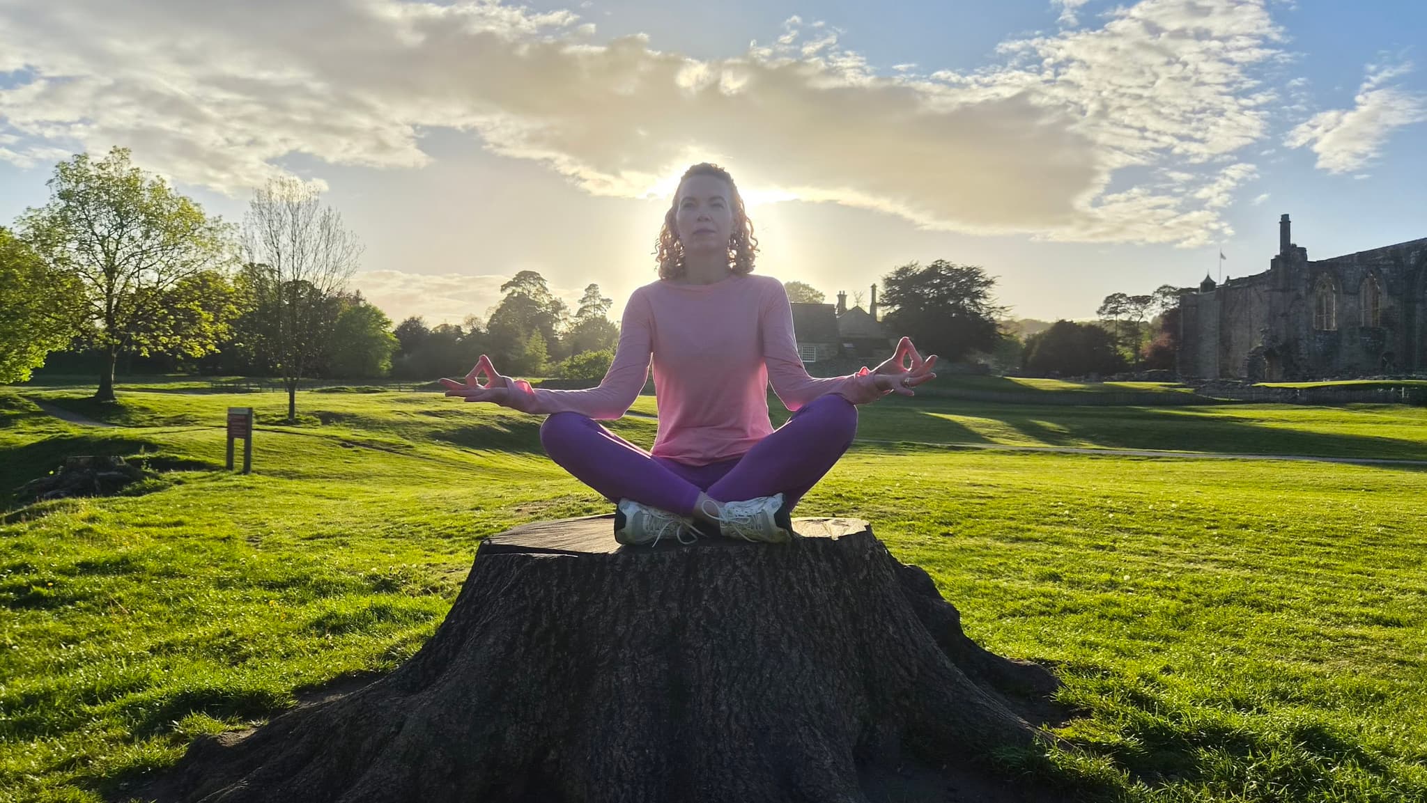 Victoria meditating in a park in Skipton at golden hour